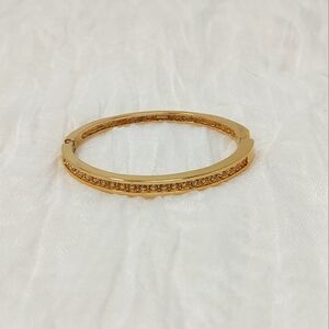 Thin bright gold tone bangle bracelet with small row of studded crystals